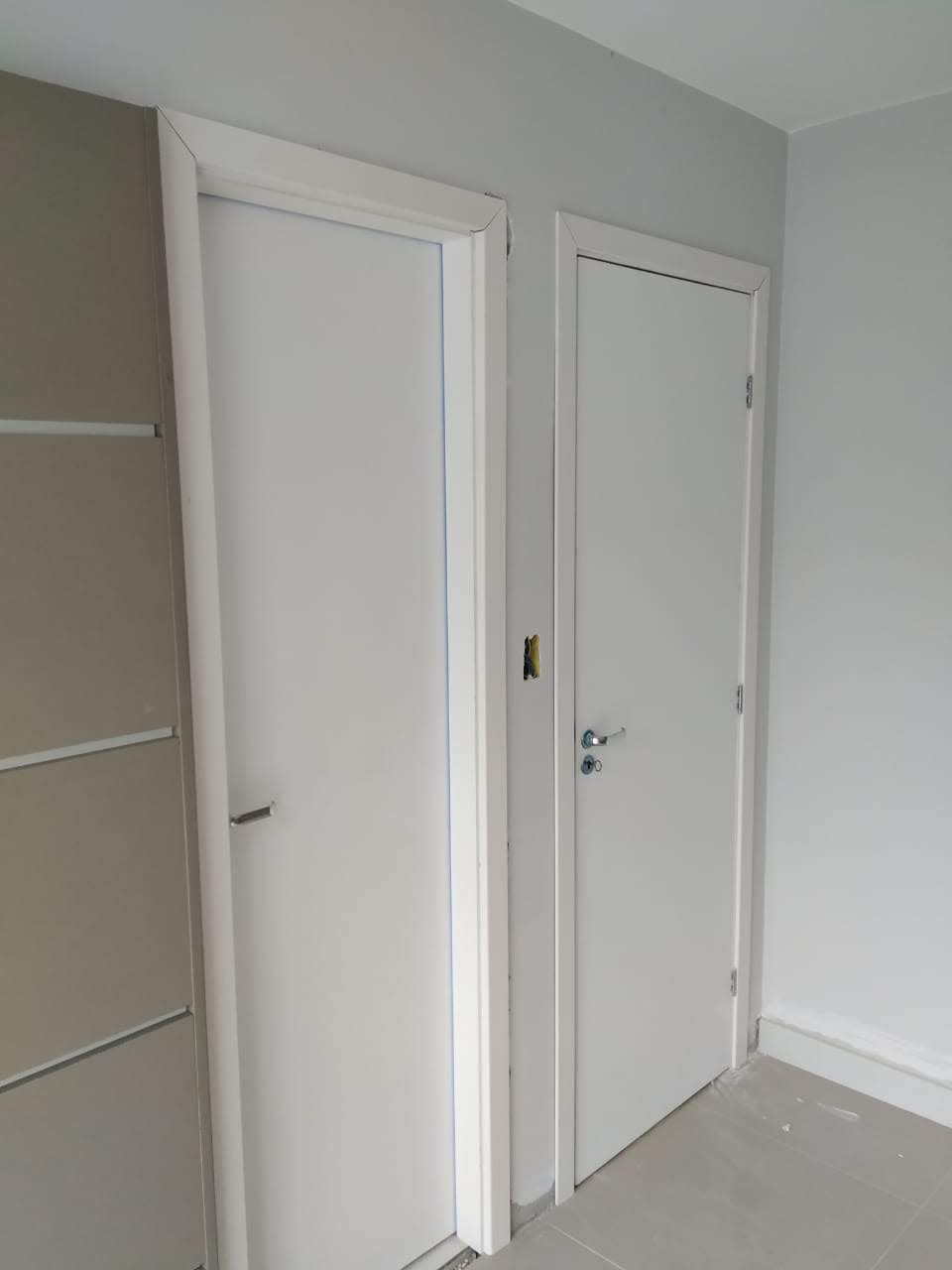Há duas portas brancas na sala.