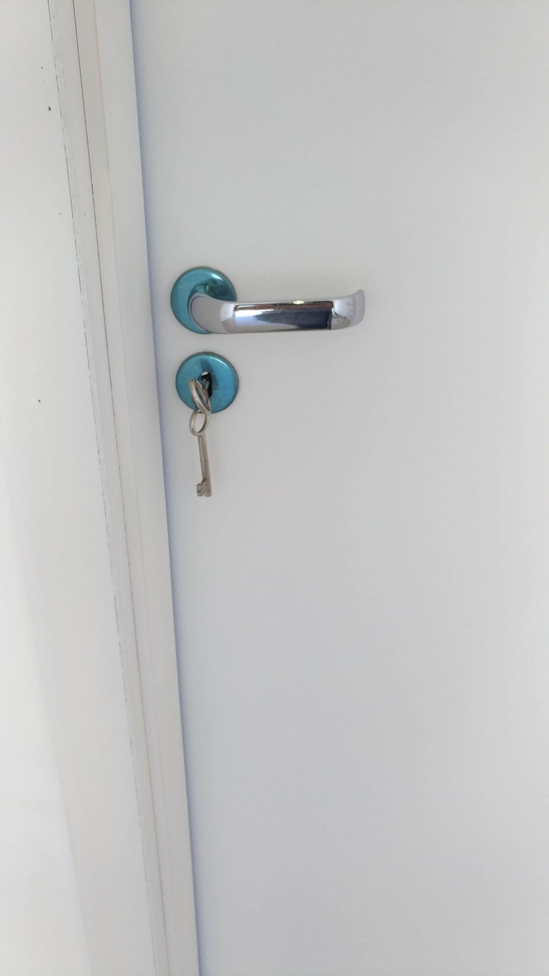 Uma porta branca com uma chave na fechadura.