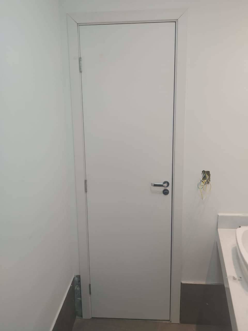 Um banheiro com uma porta branca e uma pia.