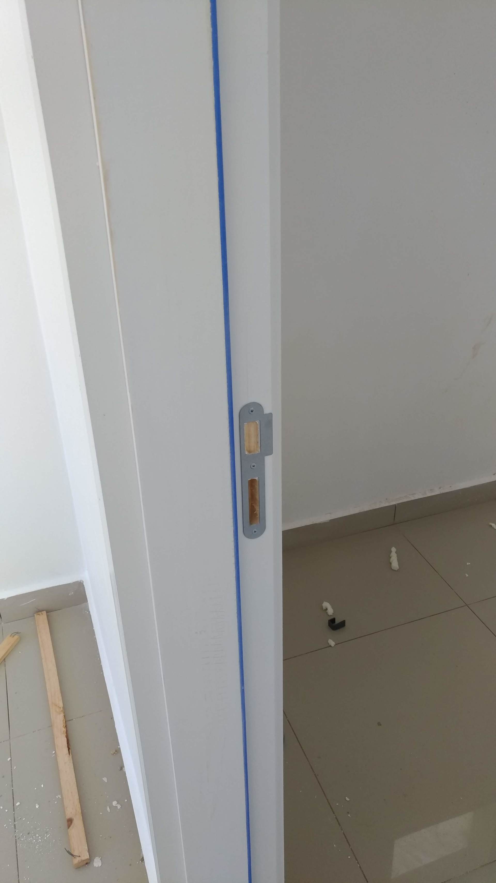 Uma porta branca está sendo pintada em uma sala.