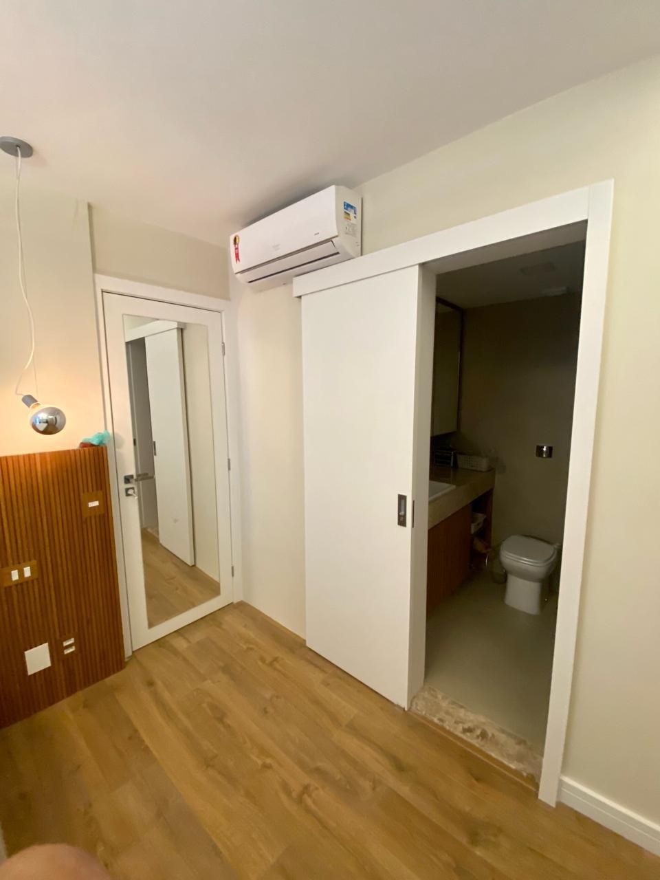 Um quarto com uma porta de correr que leva a um banheiro.