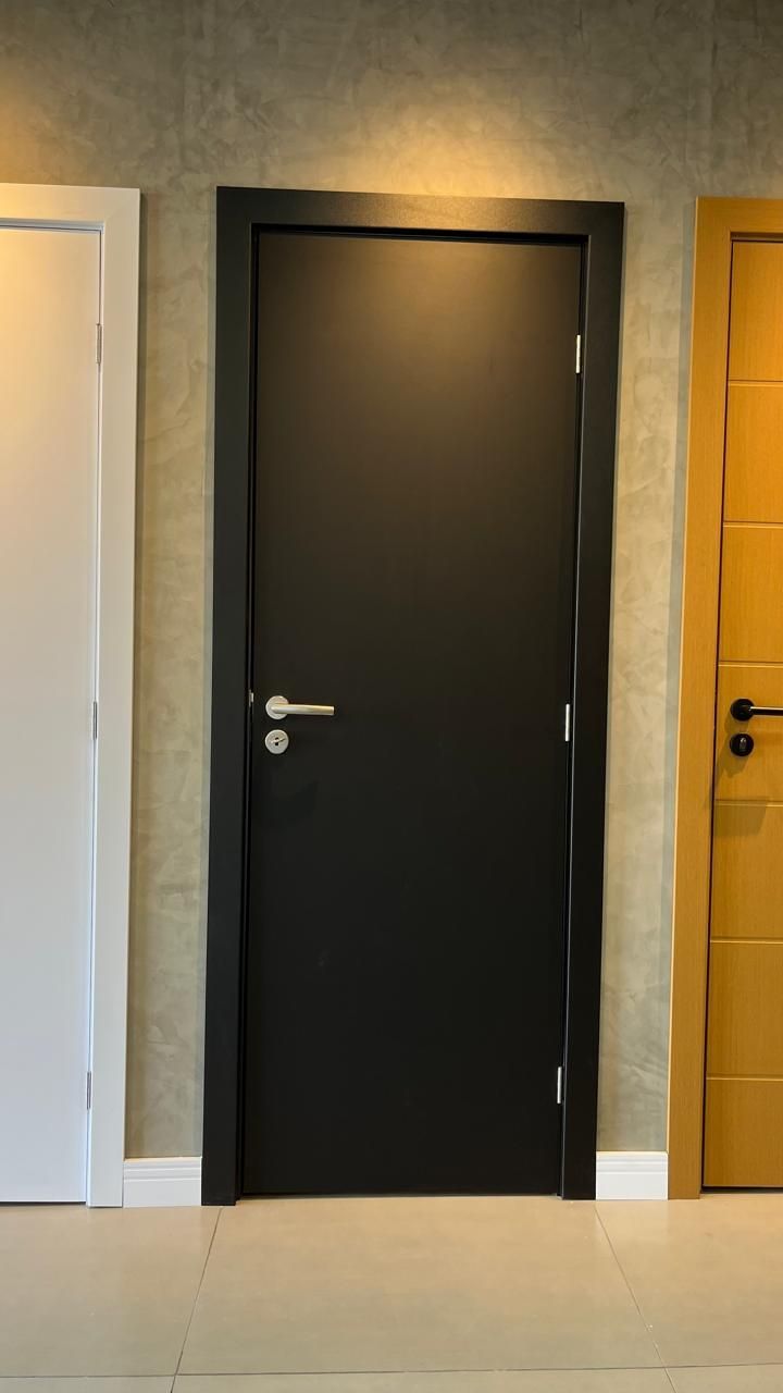Uma porta preta está ao lado de uma porta branca e uma porta amarela.