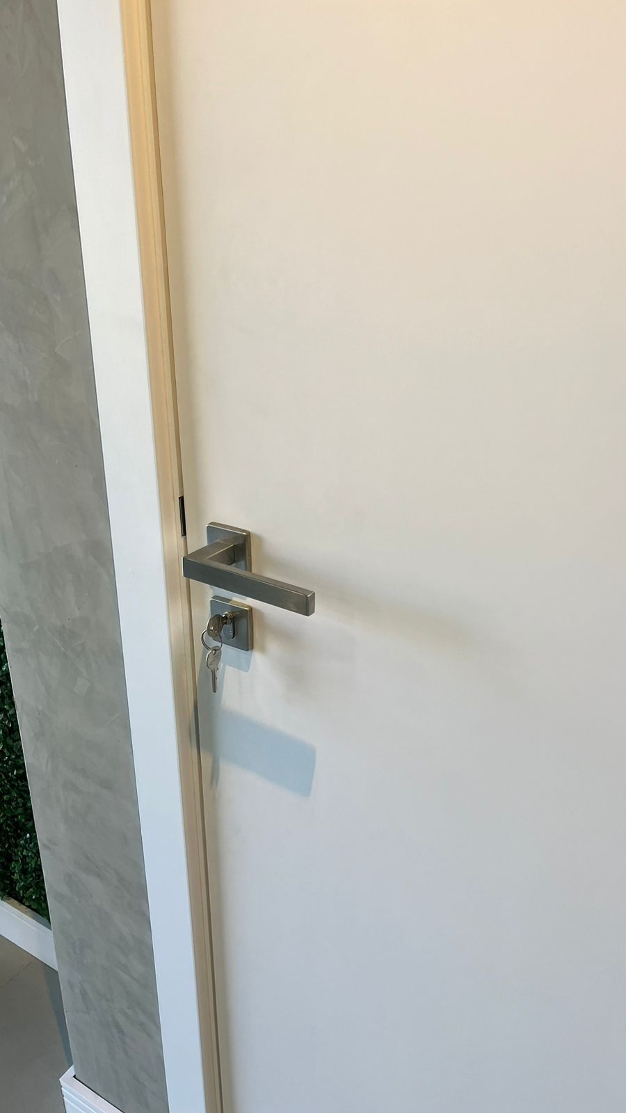 Um close de uma porta branca com uma maçaneta.