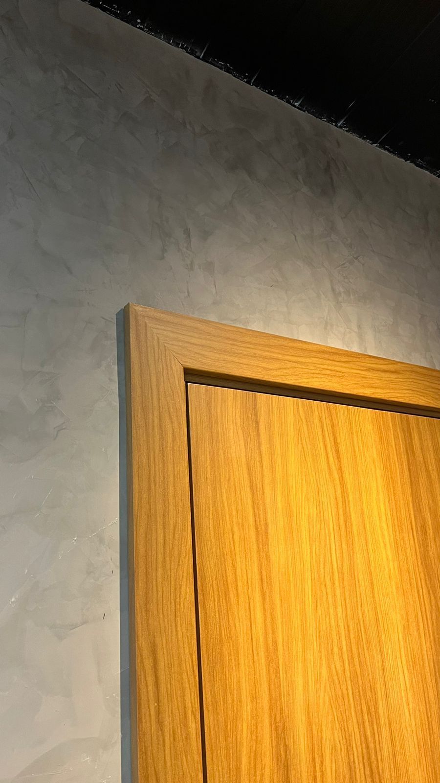 Um close de uma porta de madeira com uma moldura de madeira em uma parede.