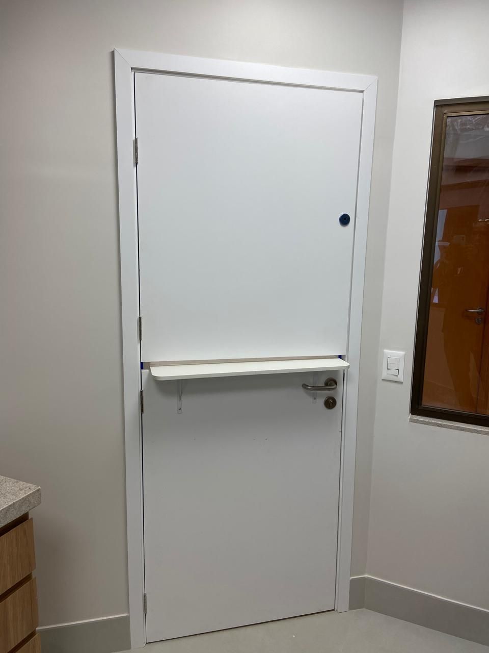Uma porta branca em uma sala com janela
