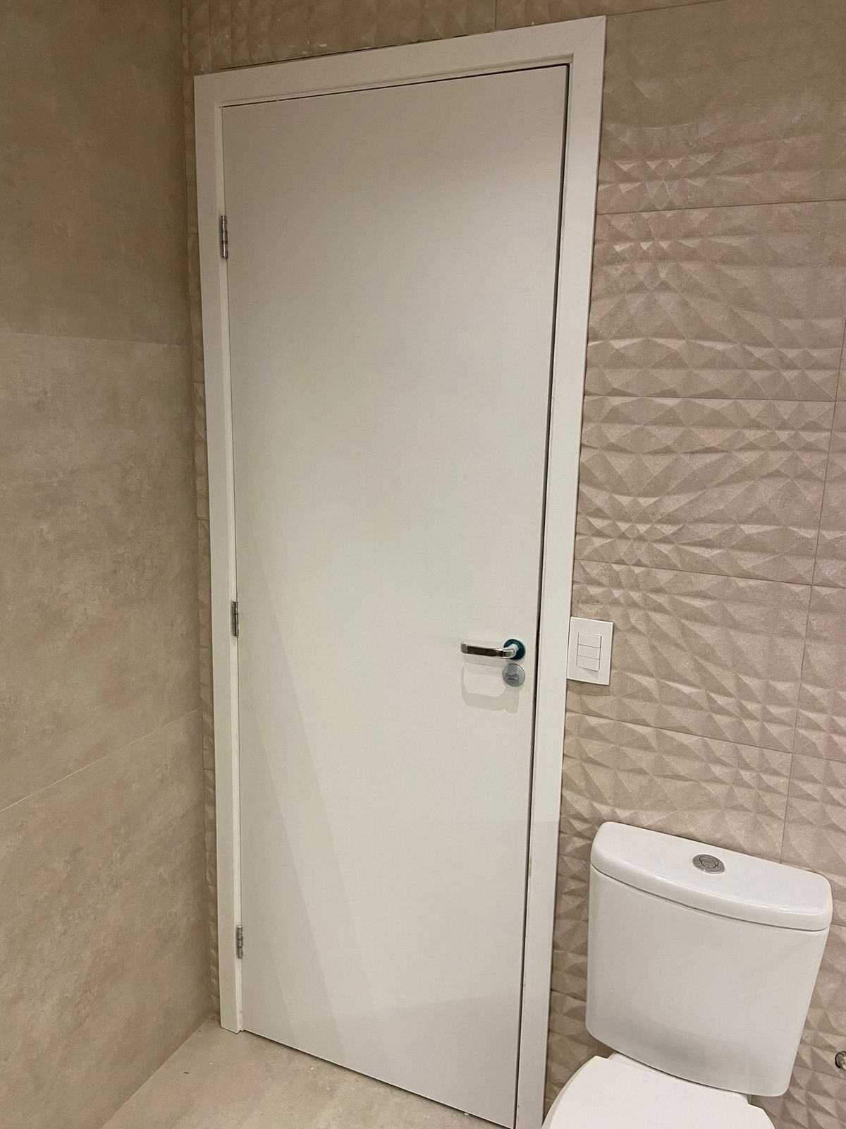 Um banheiro com vaso sanitário e uma porta branca.