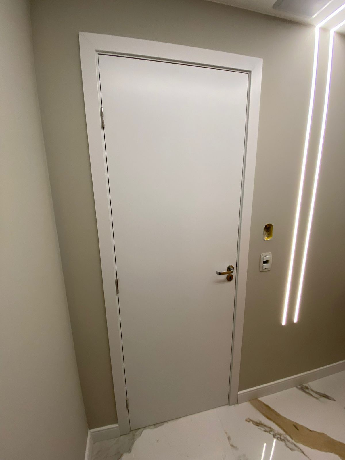 Uma porta branca em uma sala com piso de mármore