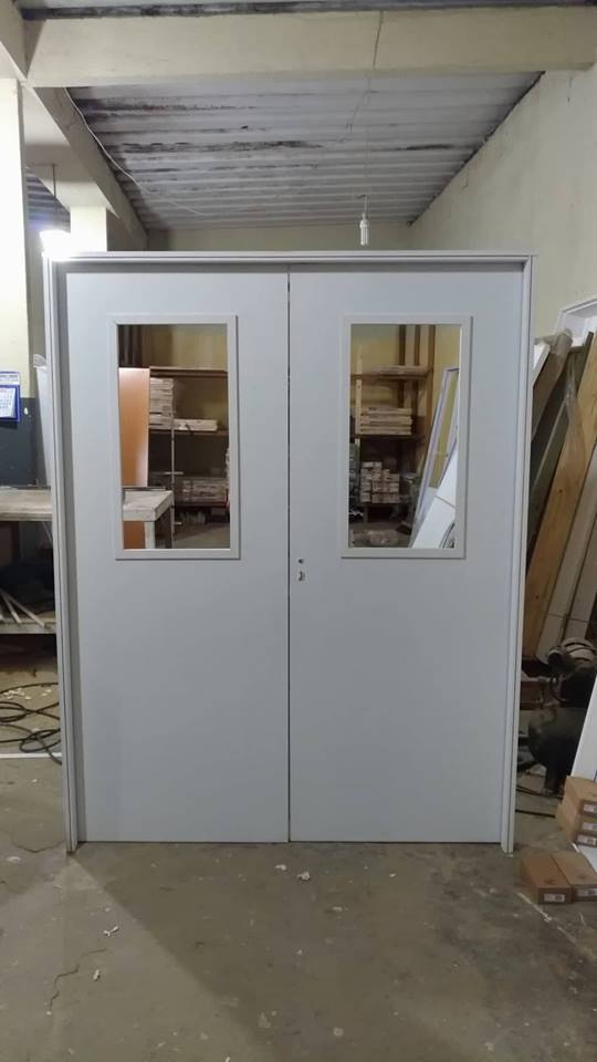 Um par de portas brancas com janelas em uma sala.