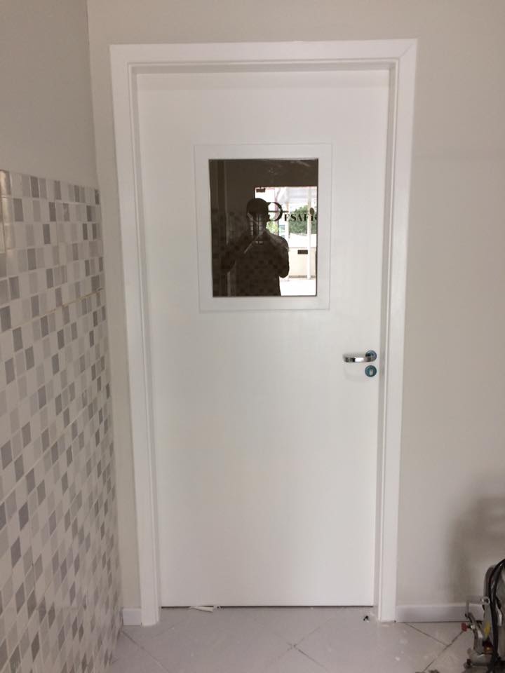 Um homem está tirando uma foto de si mesmo em um espelho na porta.