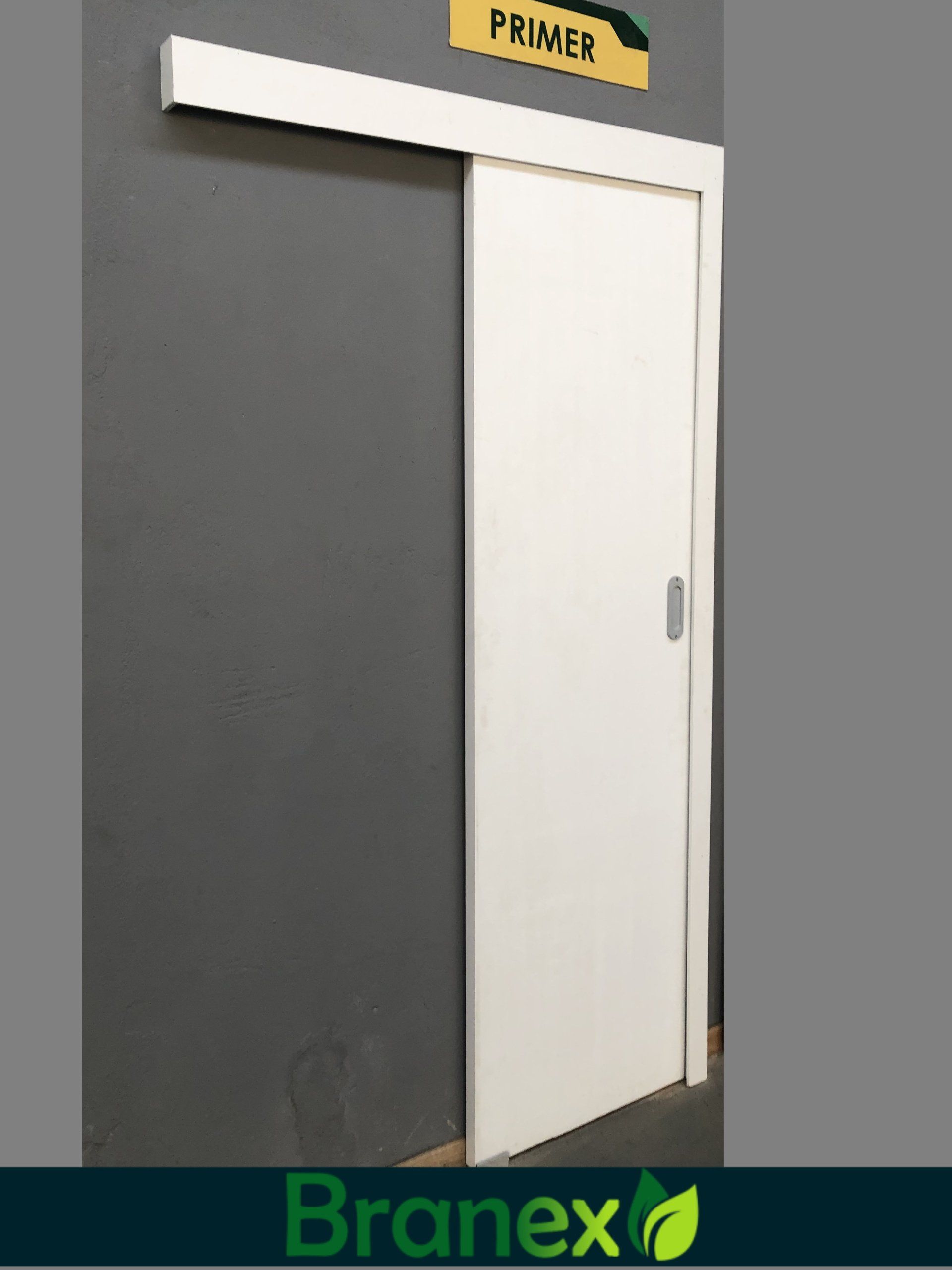 Uma porta de correr branca com uma placa de primer acima dela