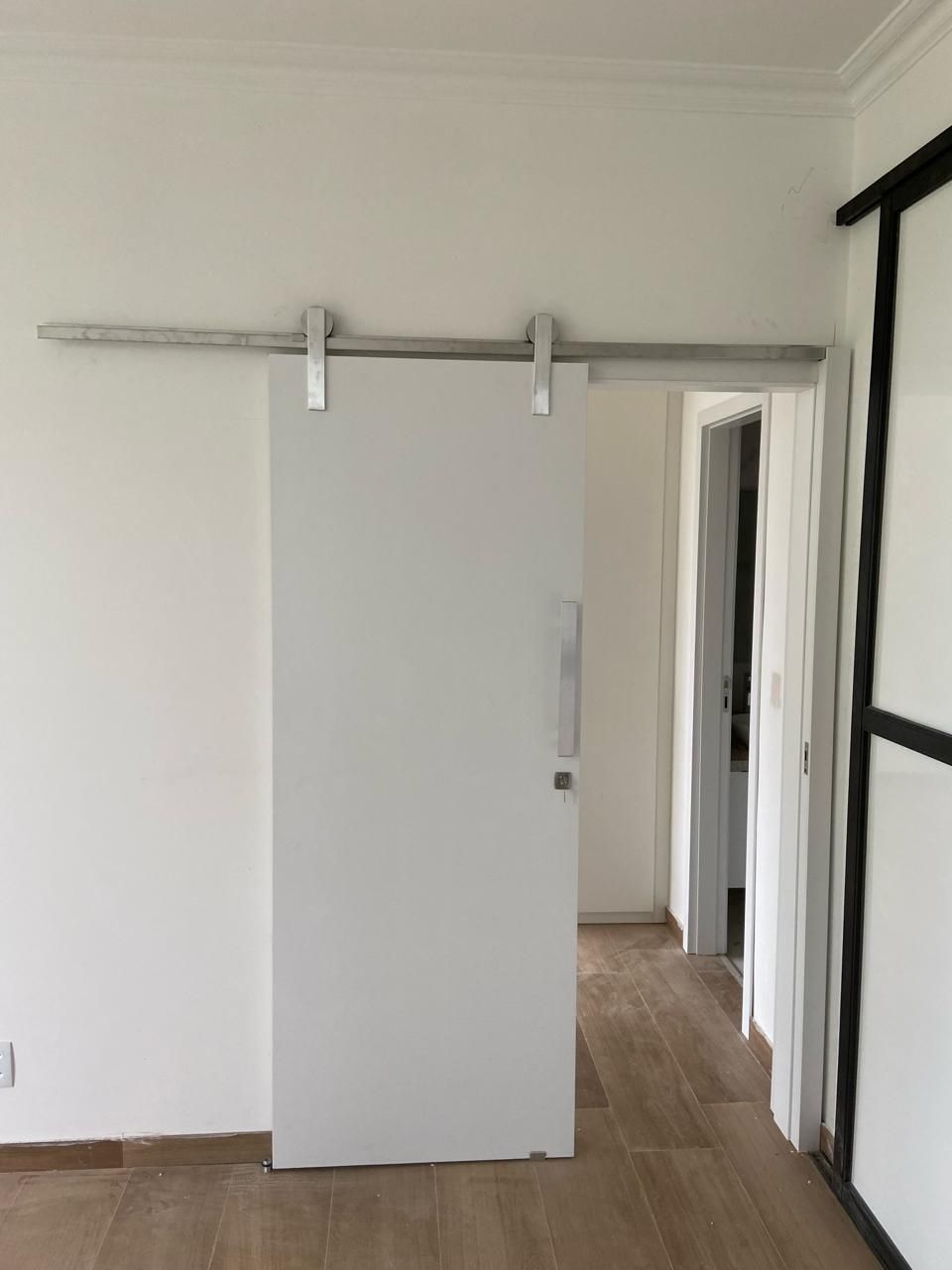 Há uma porta de celeiro deslizante no meio de uma sala.