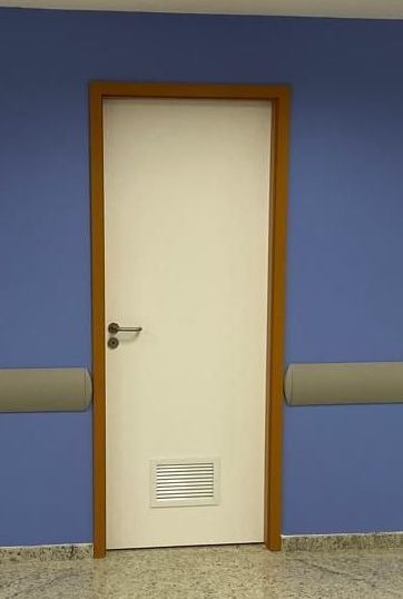 Uma porta branca com uma moldura de madeira está contra uma parede azul.