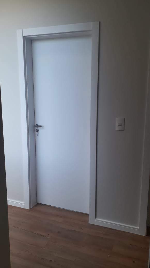 Uma porta branca com piso de madeira em uma sala.