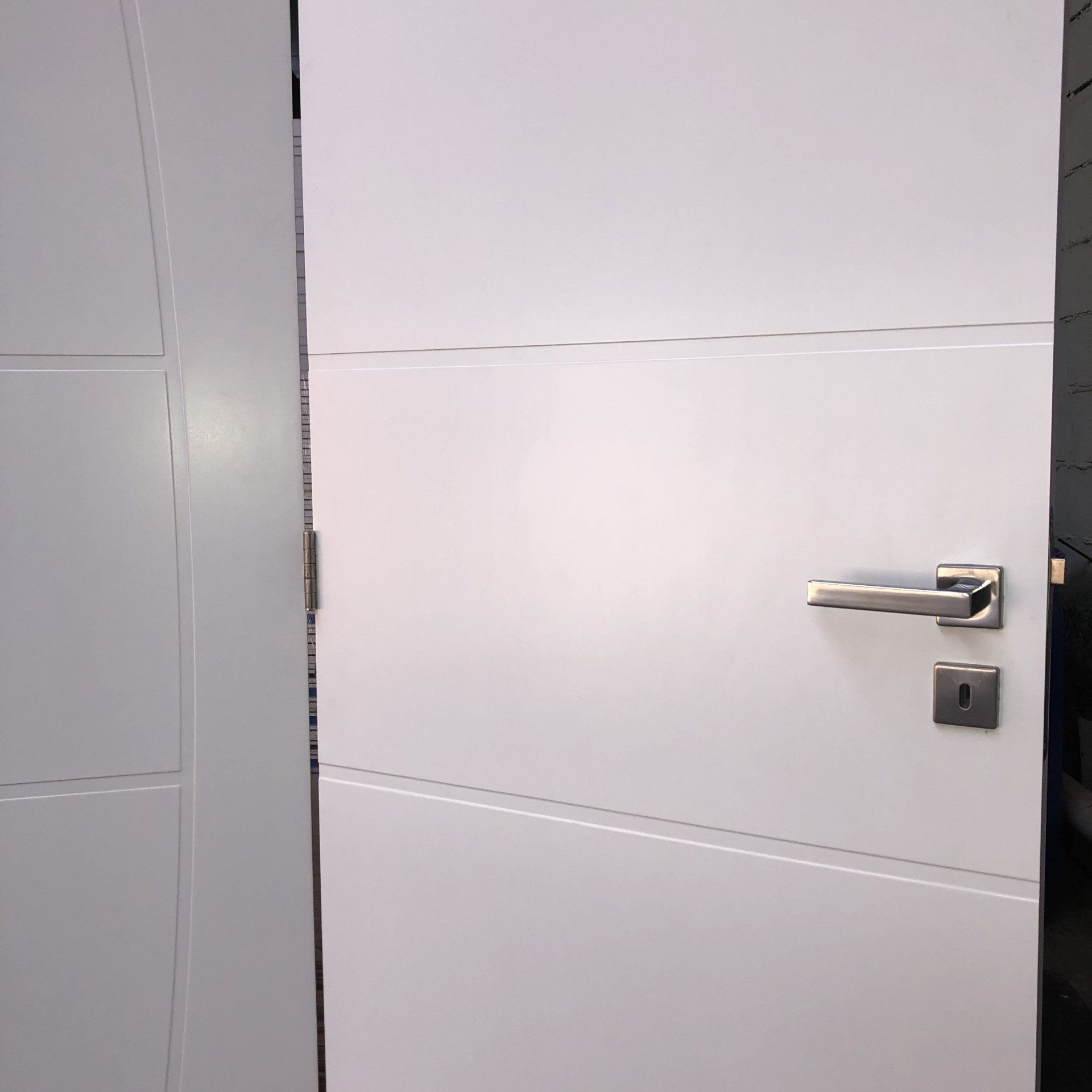 Um close de uma porta branca com uma maçaneta prateada