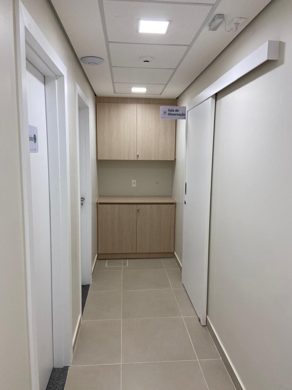 Um longo corredor com portas de correr e armários