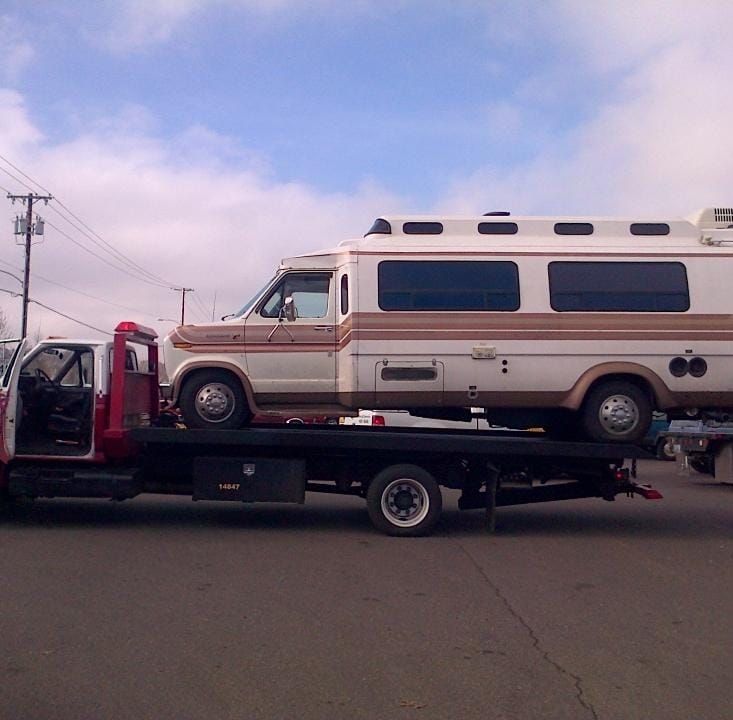A rv is being towed by a tow truck
