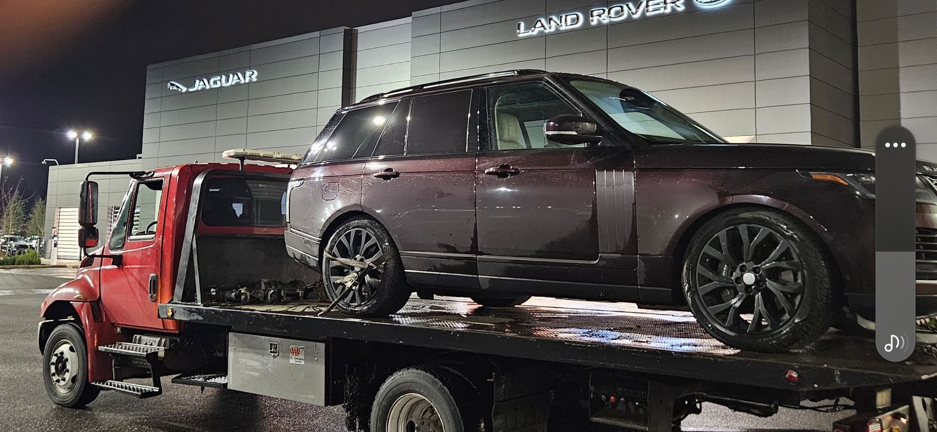 A range rover is being towed by a tow truck.