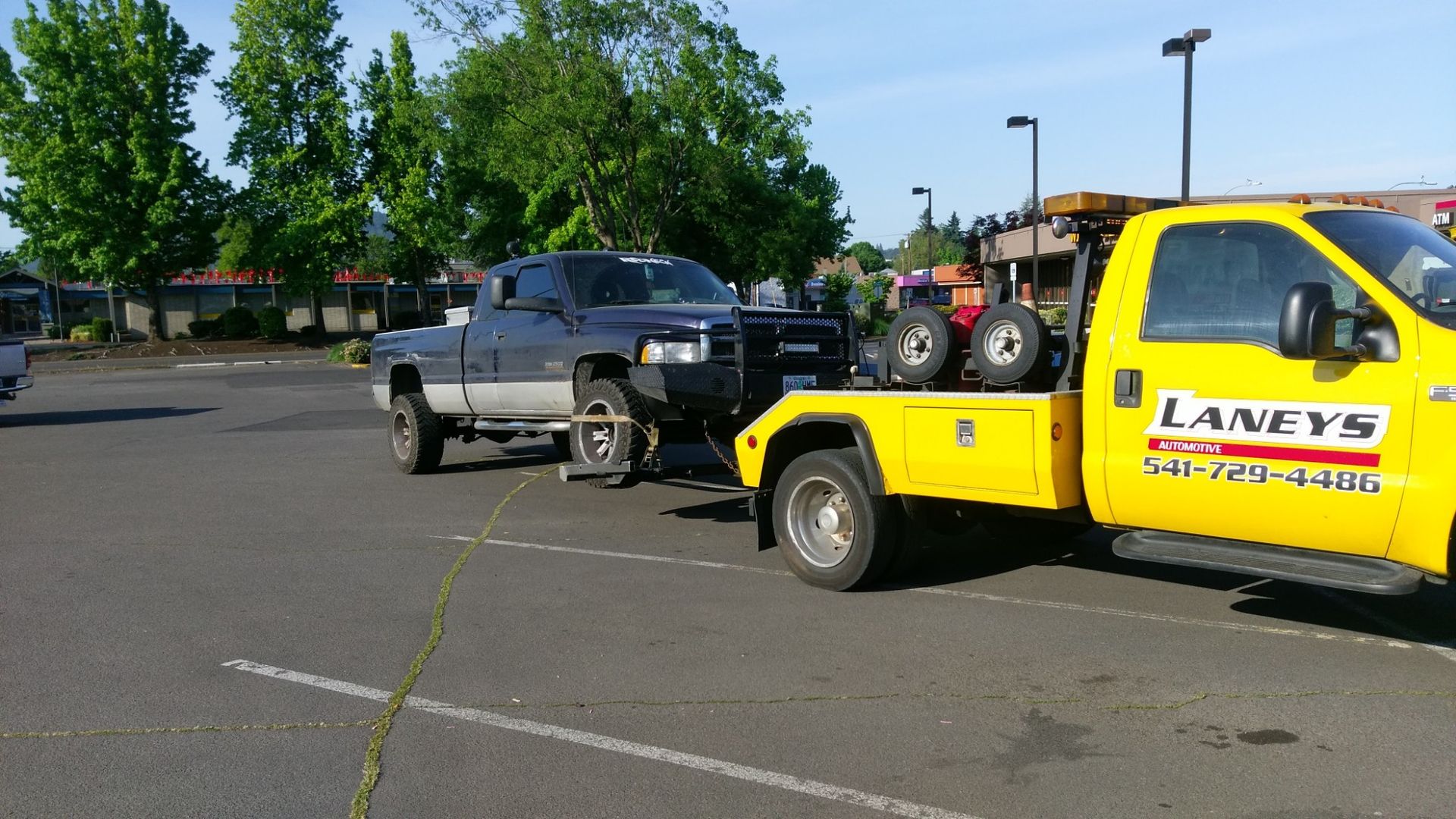 A yellow tow truck with lanfy 's written on it