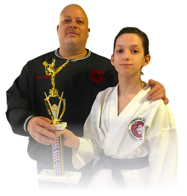 Man pointing, smiling, wearing black hoodie; arm tattoo visible.