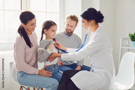 A doctor is listening to a child 's heart with a stethoscope.