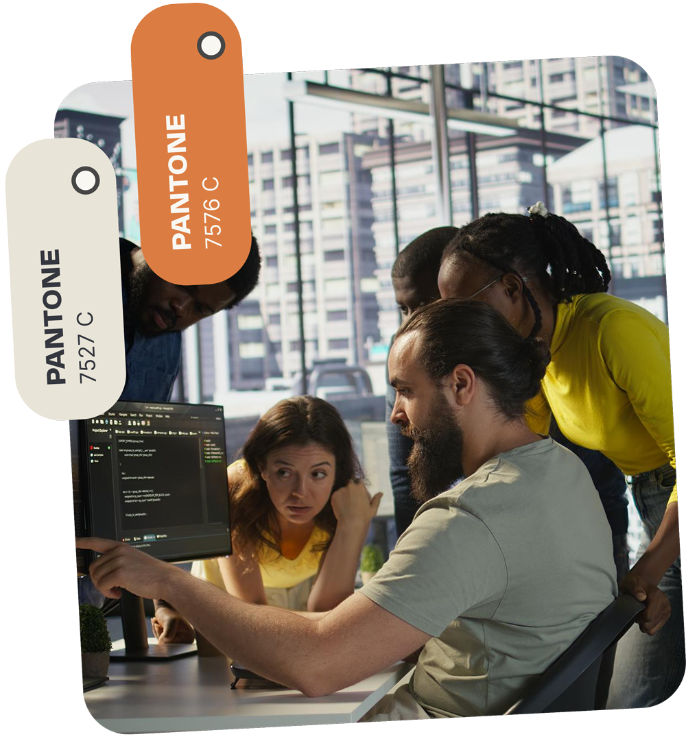 A team reviews code on a computer screen in an office setting. Two Pantone color tags overlay the image.