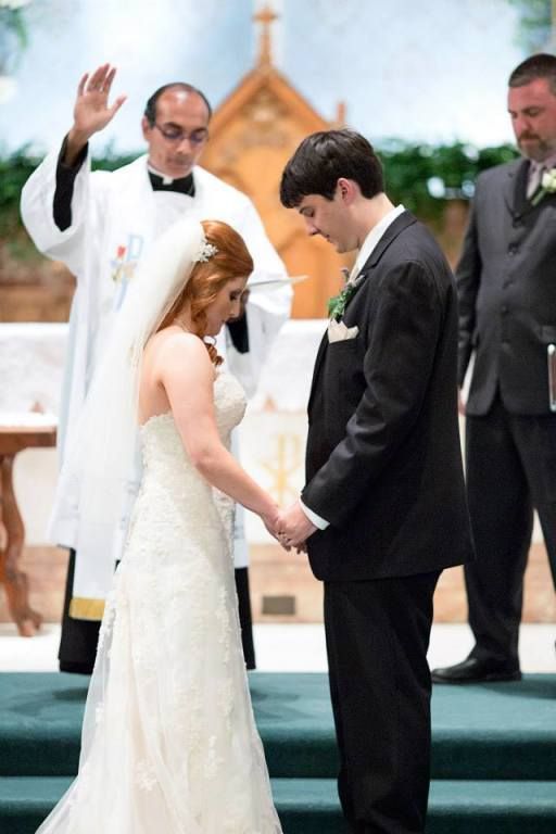 Bride and groom holding hands during a wedding ceremony, with an officiant in the background