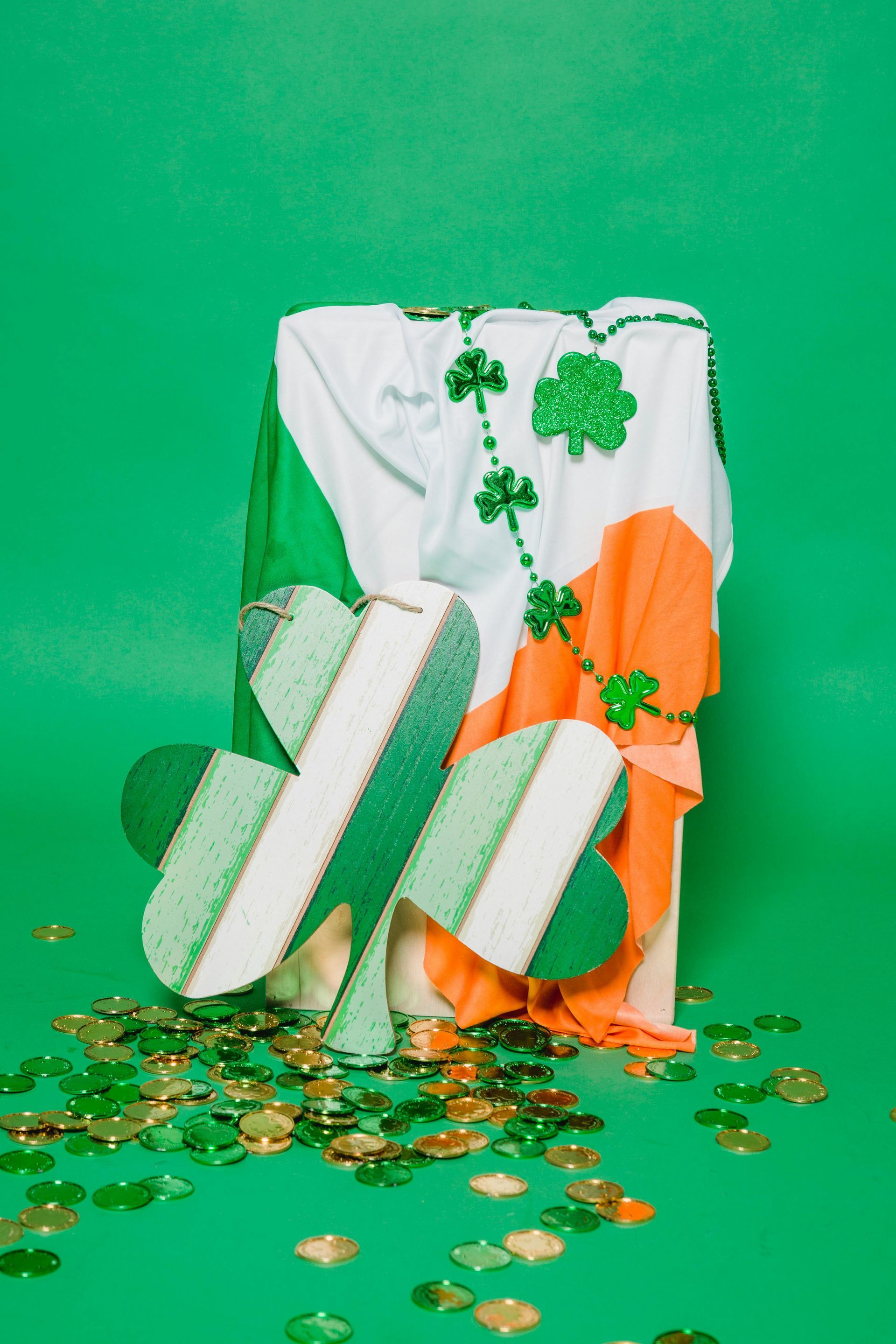 A green and orange flag with shamrocks on it is on a green background.