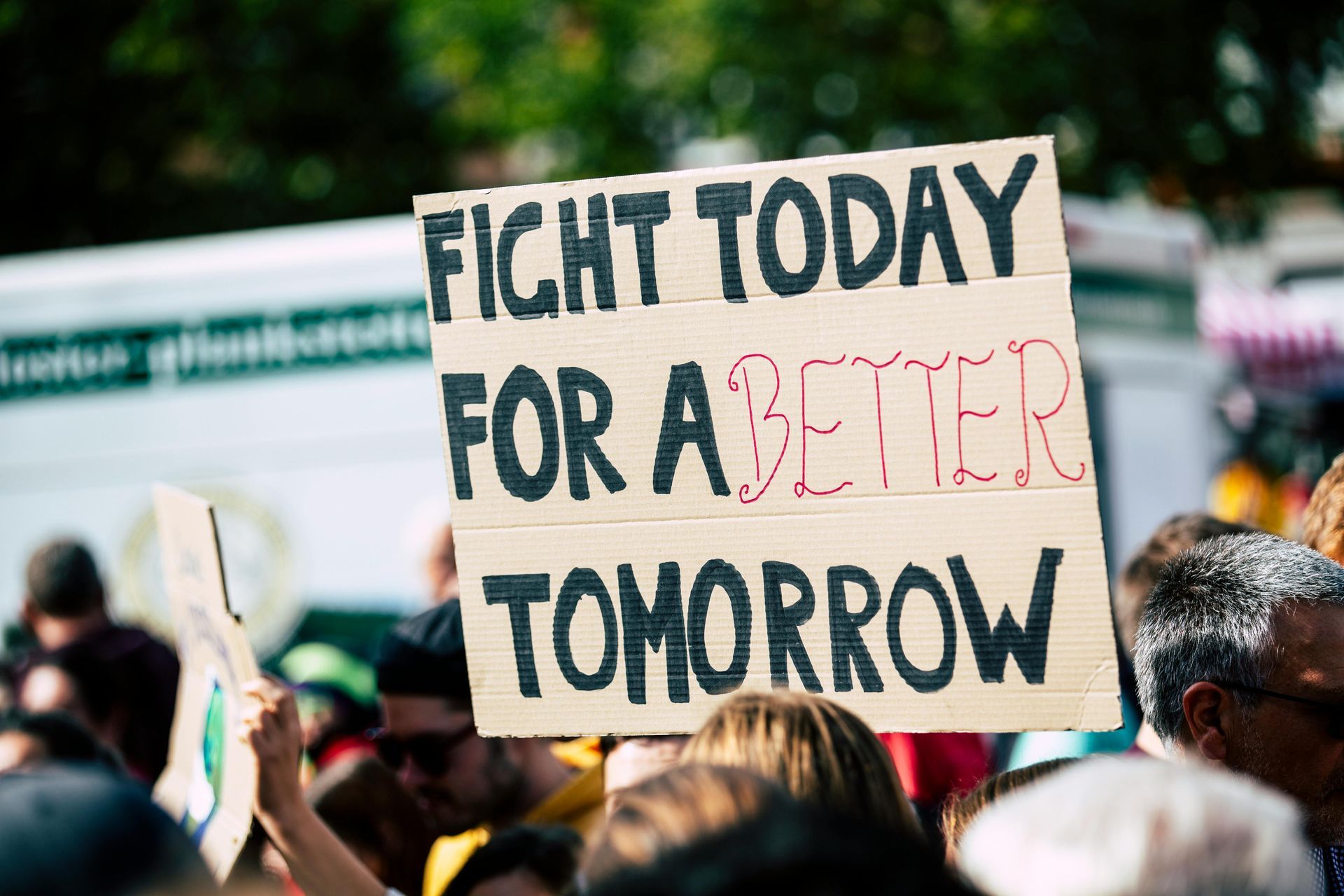 A group of people are holding a sign that says `` fight today for a better tomorrow ''.