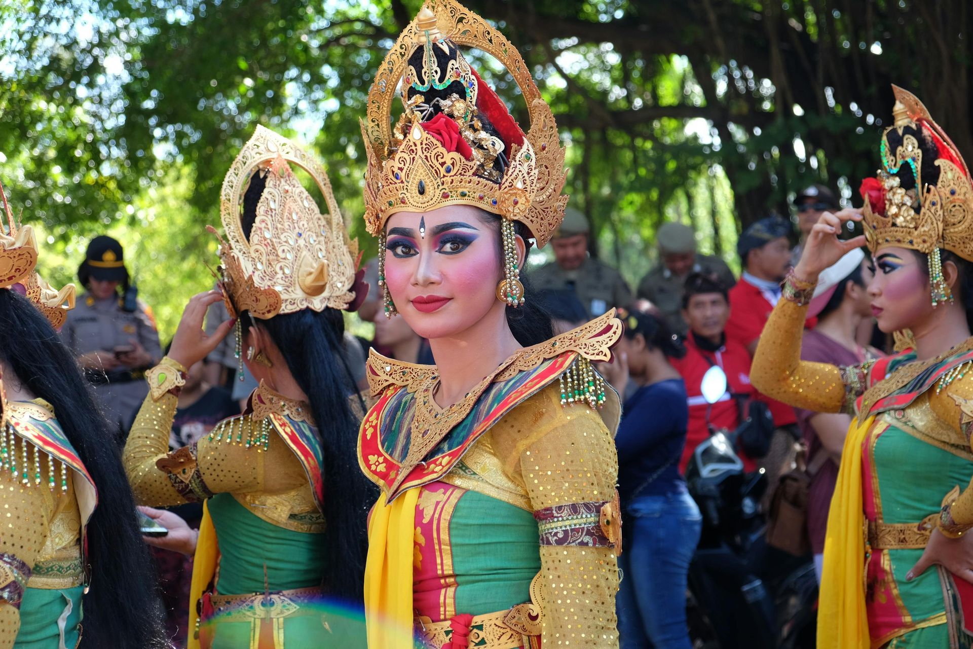 A group of women in traditional costumes are standing in front of a crowd.