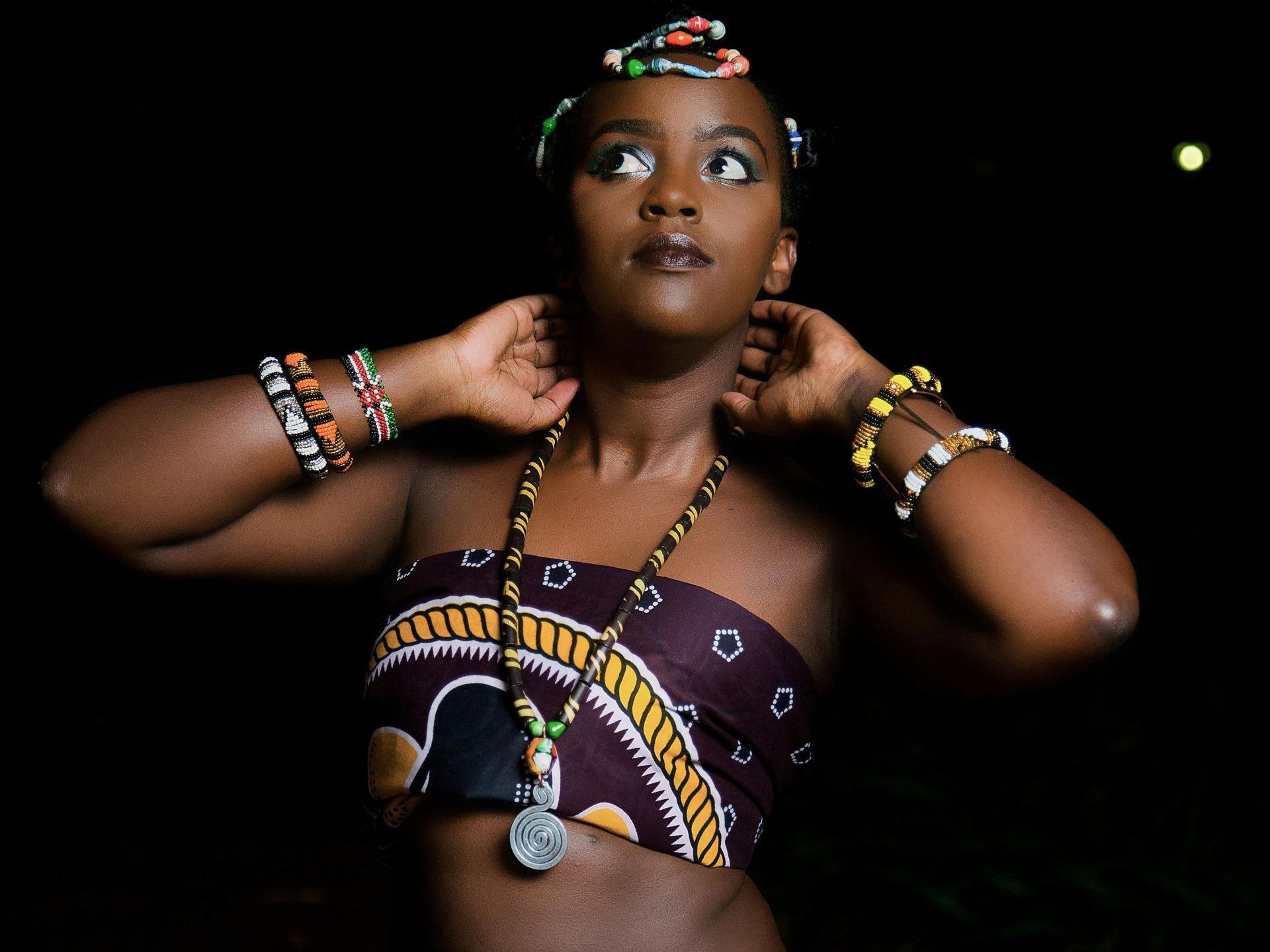 African woman in traditional garb standing on stage.