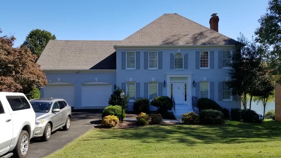 A white house with two cars parked in front of it