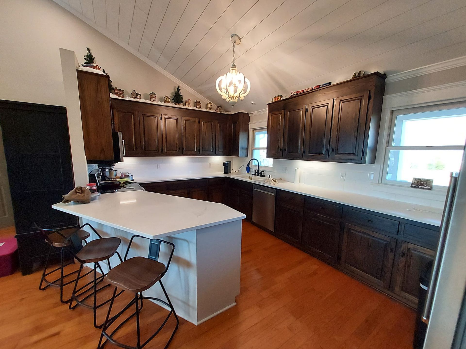 A kitchen with brown cabinets and white counter tops