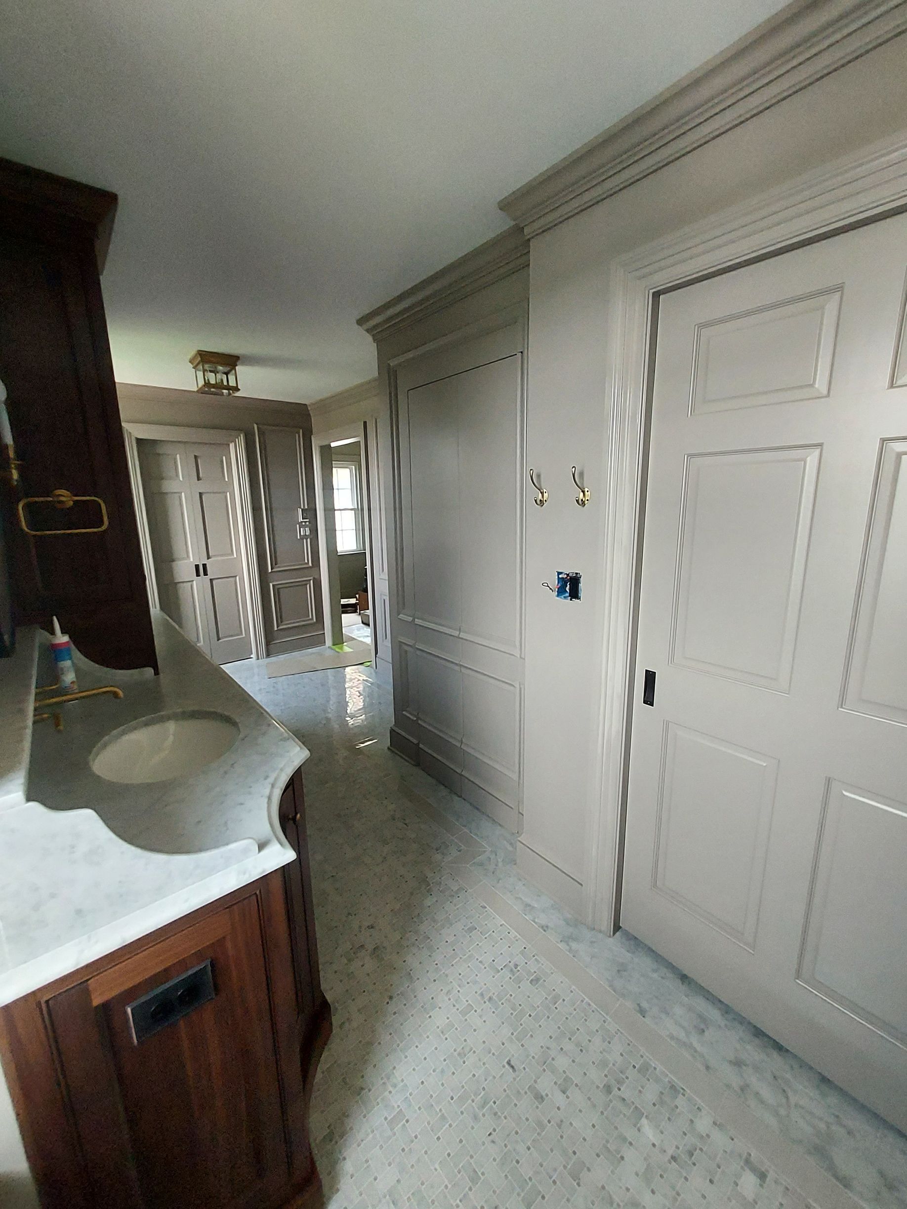 Custom finished shadow boxing painted to match custom cabinetry throughout master bath complete with pocket doors