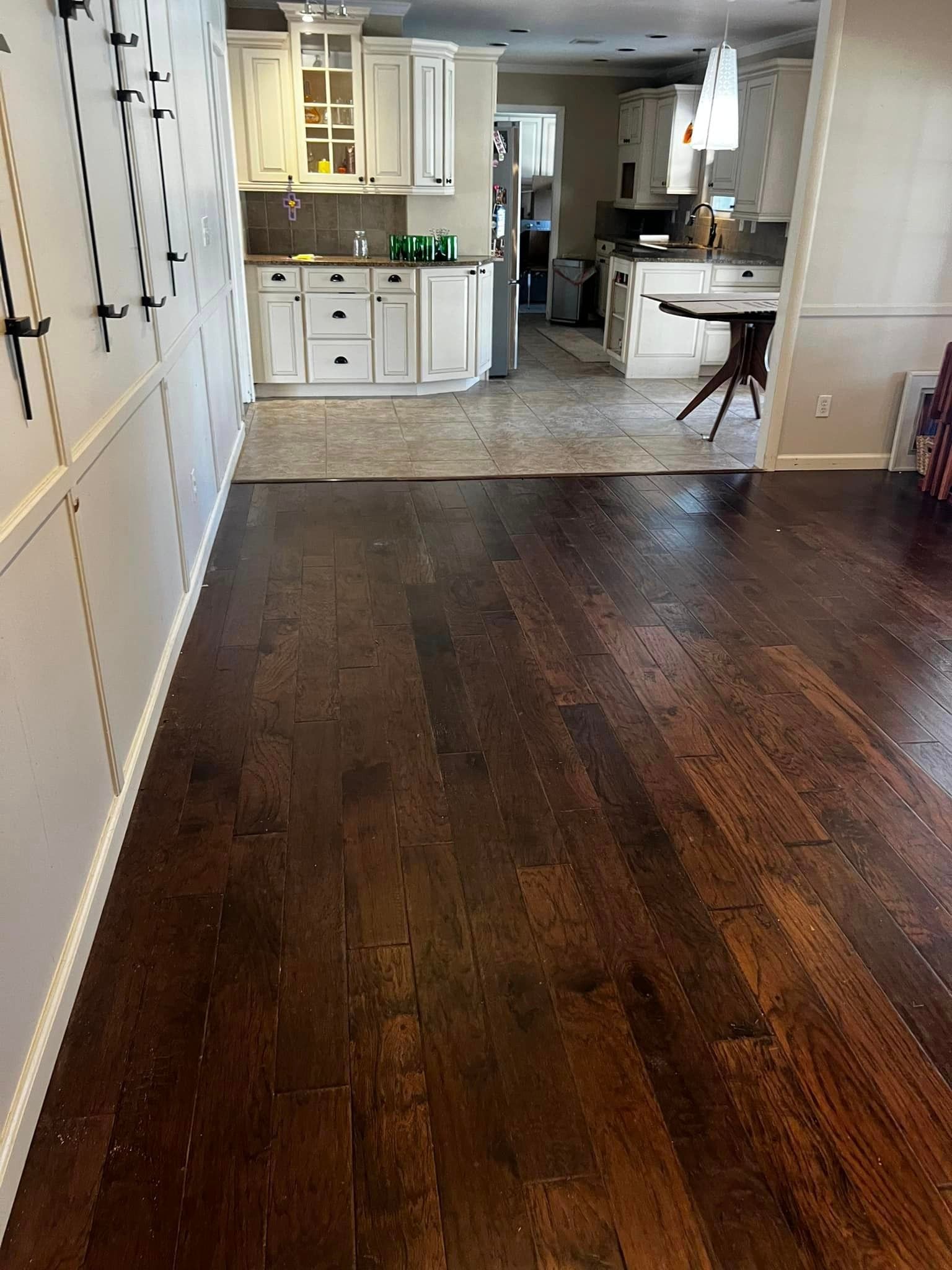 A kitchen with a wooden floor and white cabinets.