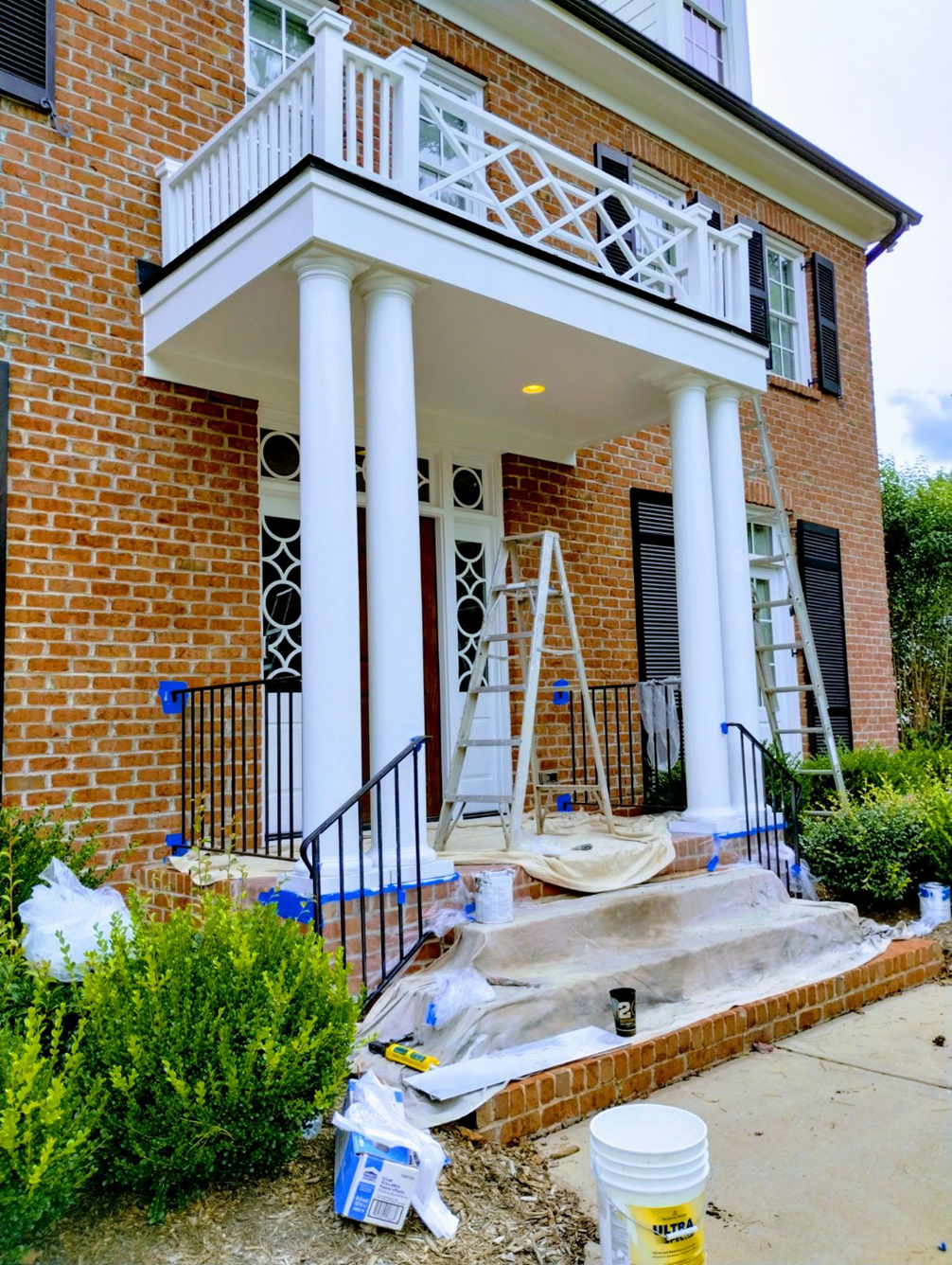 Bucket of paint sits in front of a brick house — Raleigh, NC — Untied Painting, LLC