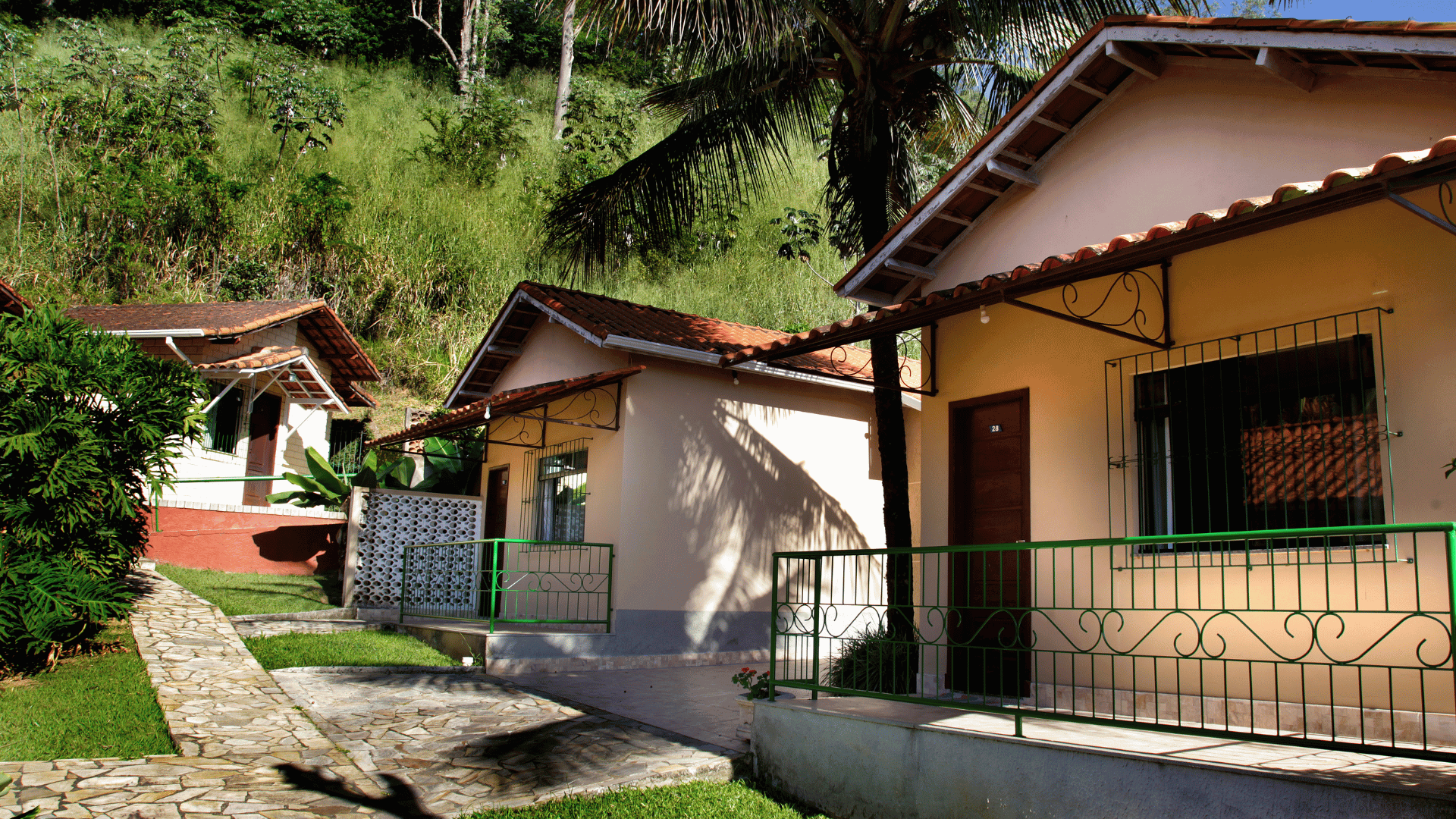 Um grupo de pequenas casas fica lado a lado na encosta de uma colina.