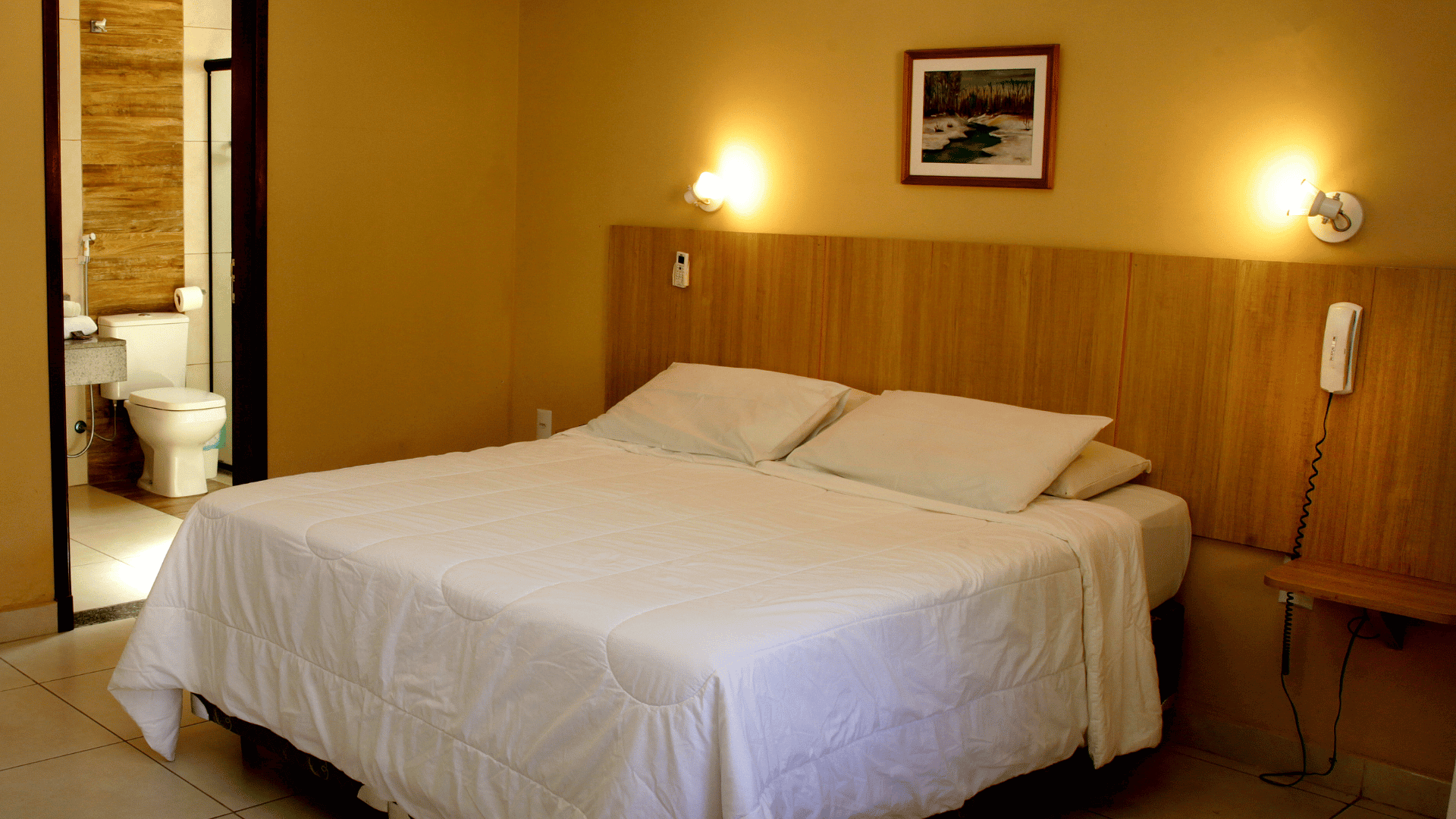 Um quarto de hotel com uma cama grande e um banheiro.