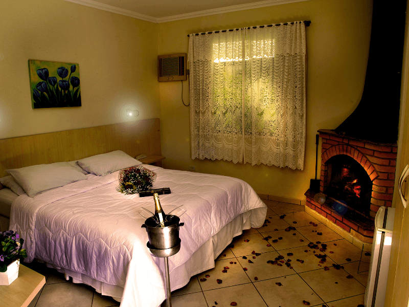 Um quarto com lareira e uma cama grande