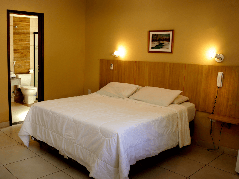 Um quarto de hotel com uma cama e um quadro na parede