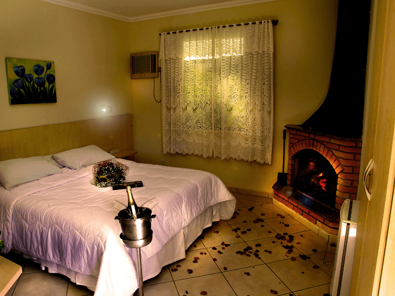 Um quarto com lareira e uma cama grande