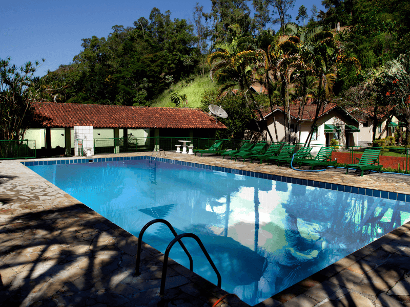 Uma grande piscina cercada por cadeiras e árvores