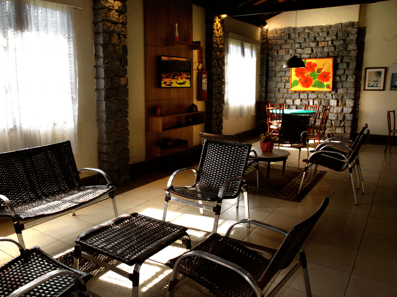 Uma sala com móveis de vime e uma pintura na parede