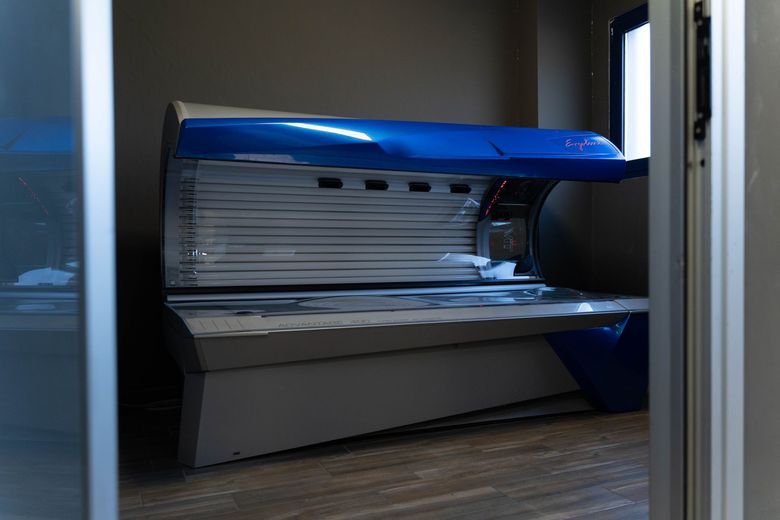 Lettino abbronzante fluorescente blu, dal design curvo, che emette luce intensa.