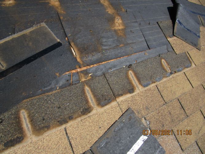 A close up of a roof with a lot of shingles missing