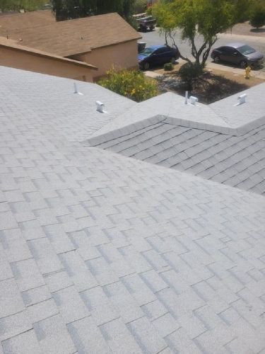 The roof of a house with a gray shingle roof.
