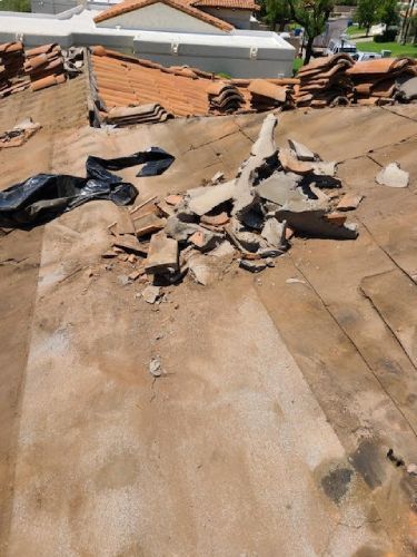 A roof with a lot of broken tiles on it.