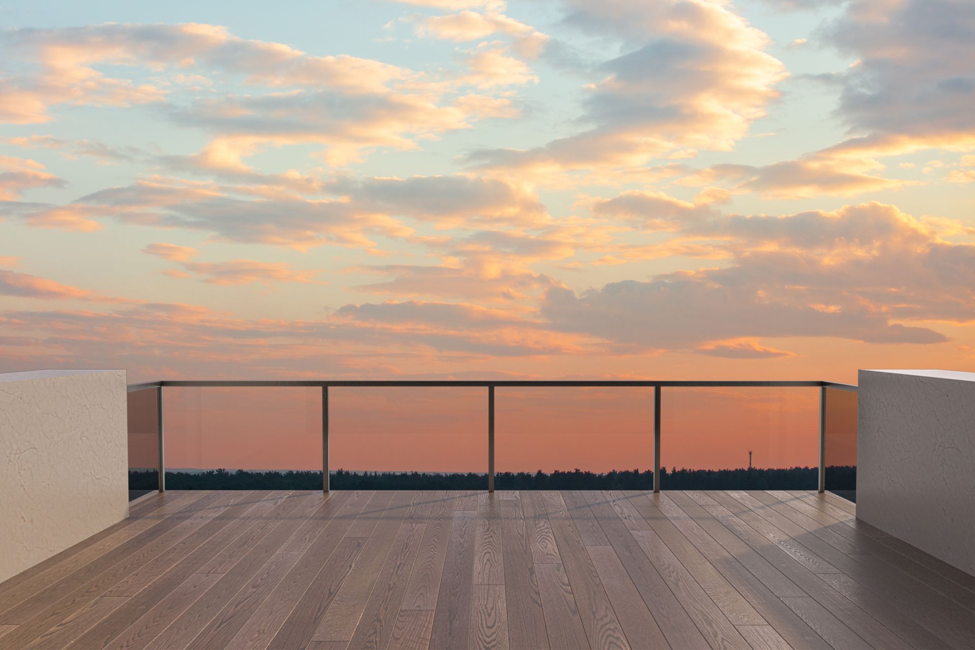 There is a balcony with a view of the ocean at sunset.