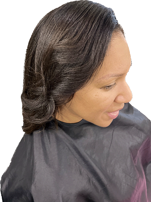 Woman with styled dark hair, looking right, wearing a black salon cape.