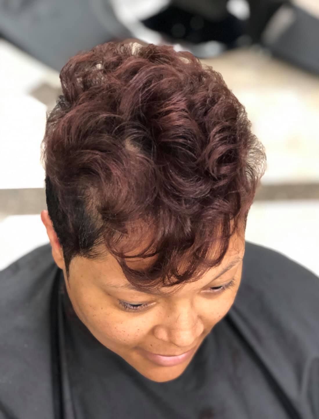 Woman with a short, wavy auburn hairstyle.