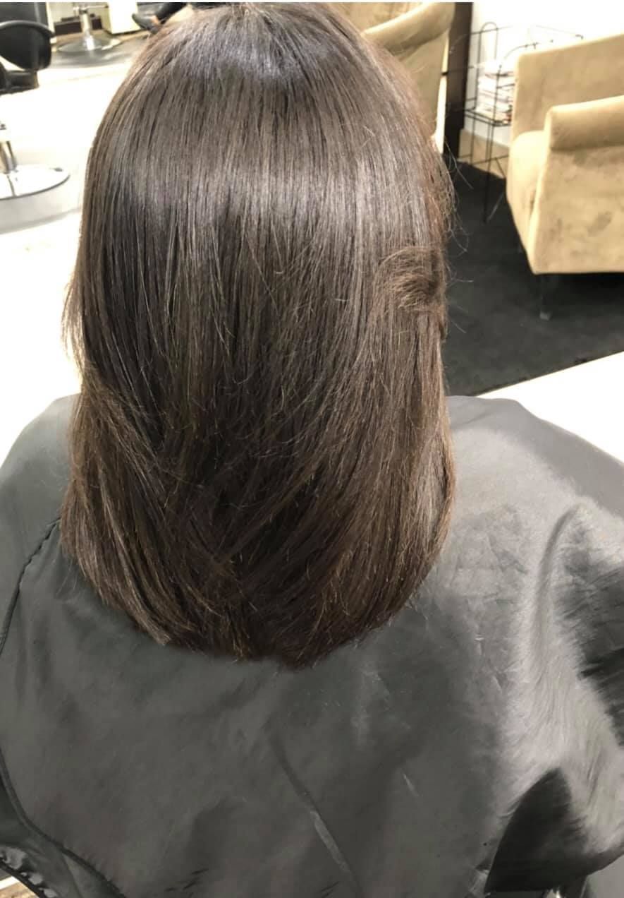 Woman's layered, dark brown hair after a haircut. 